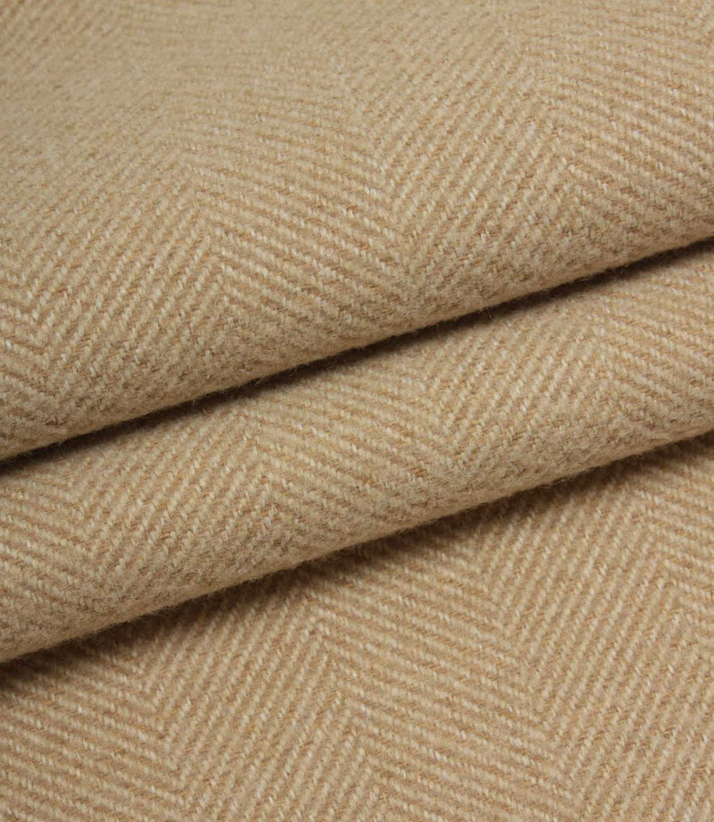 Close-up of beige herringbone fabric with a subtle pattern