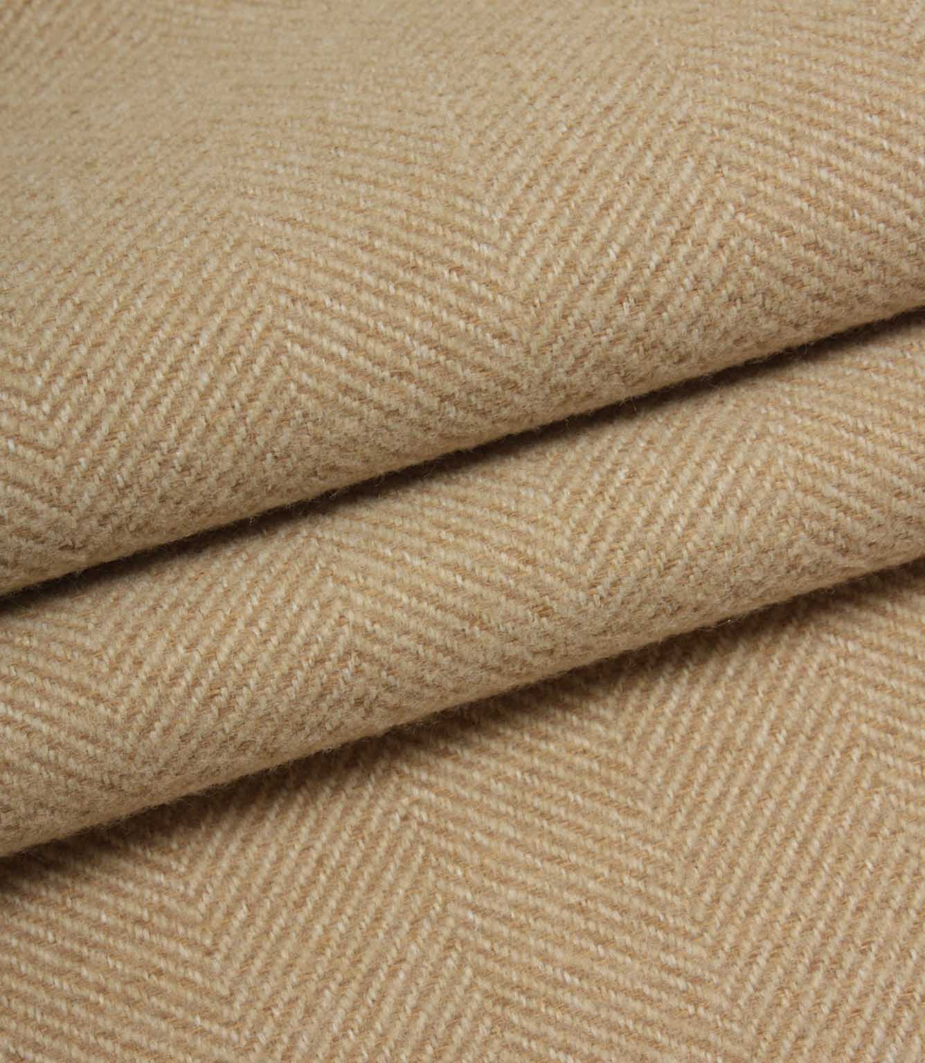 Close-up of beige herringbone fabric with a subtle pattern