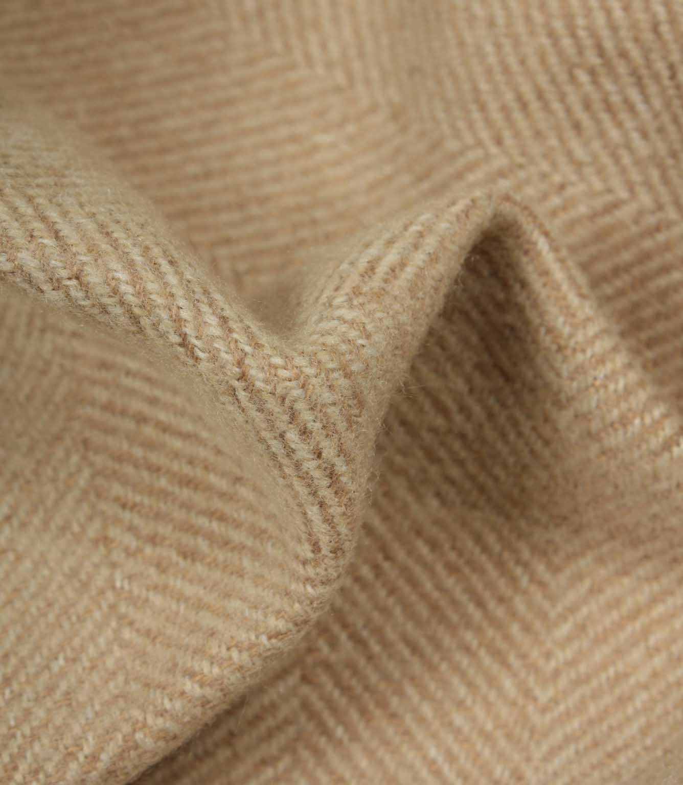 Close-up of beige fabric with a herringbone pattern