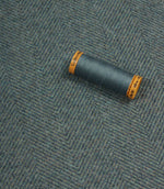 Spool of thread on a textured fabric background