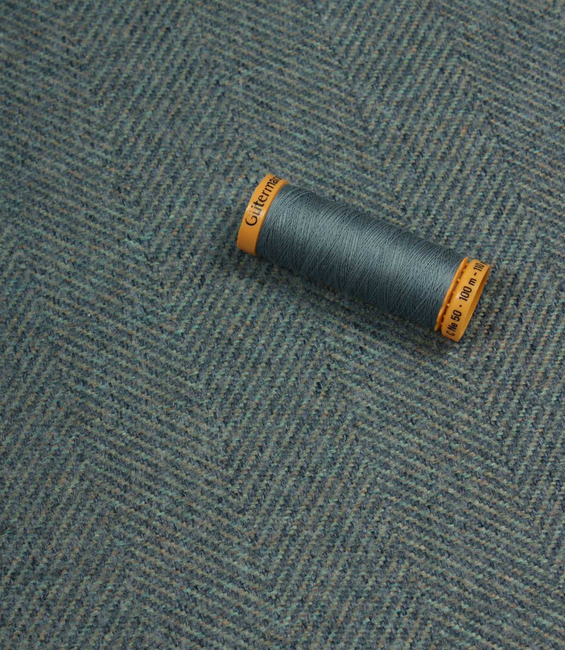 Spool of thread on a textured fabric background