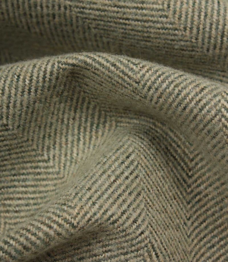 Close-up of textured green fabric with a herringbone pattern