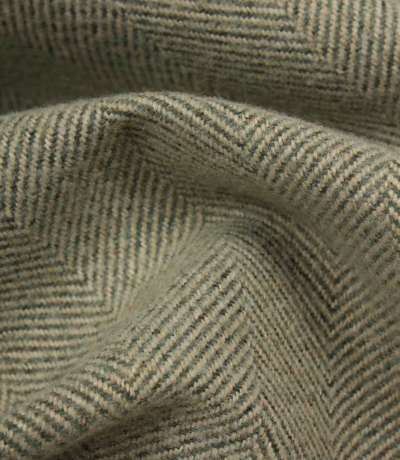 Close-up of textured green fabric with a herringbone pattern
