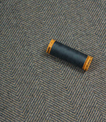Spool of thread on a textured fabric background