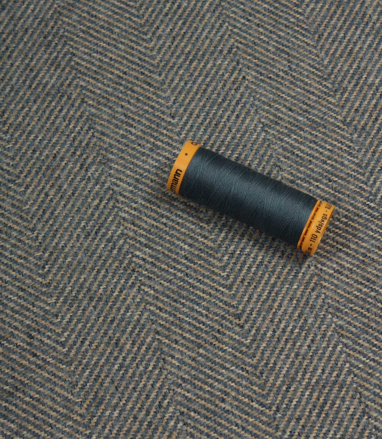 Spool of thread on a textured fabric background