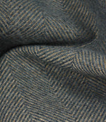 Close-up of textured fabric with a herringbone pattern in blue tones.