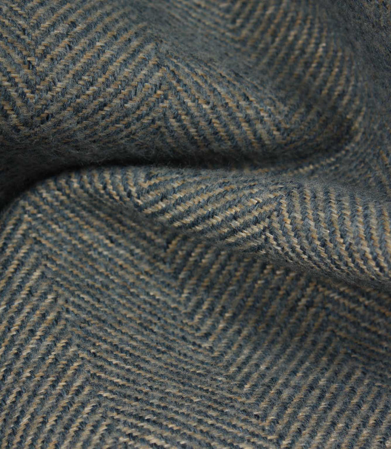 Close-up of textured fabric with a herringbone pattern in blue tones.