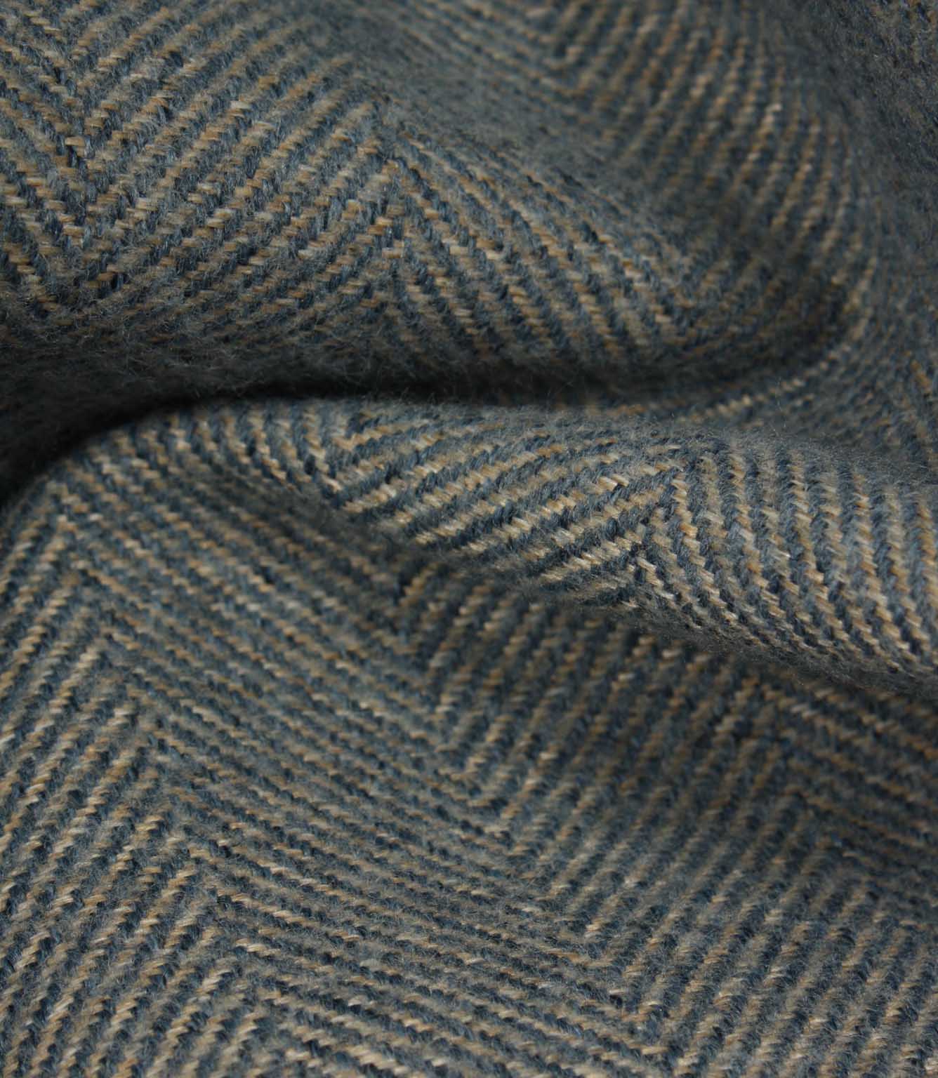Close-up of textured fabric with a herringbone pattern in blue tones.