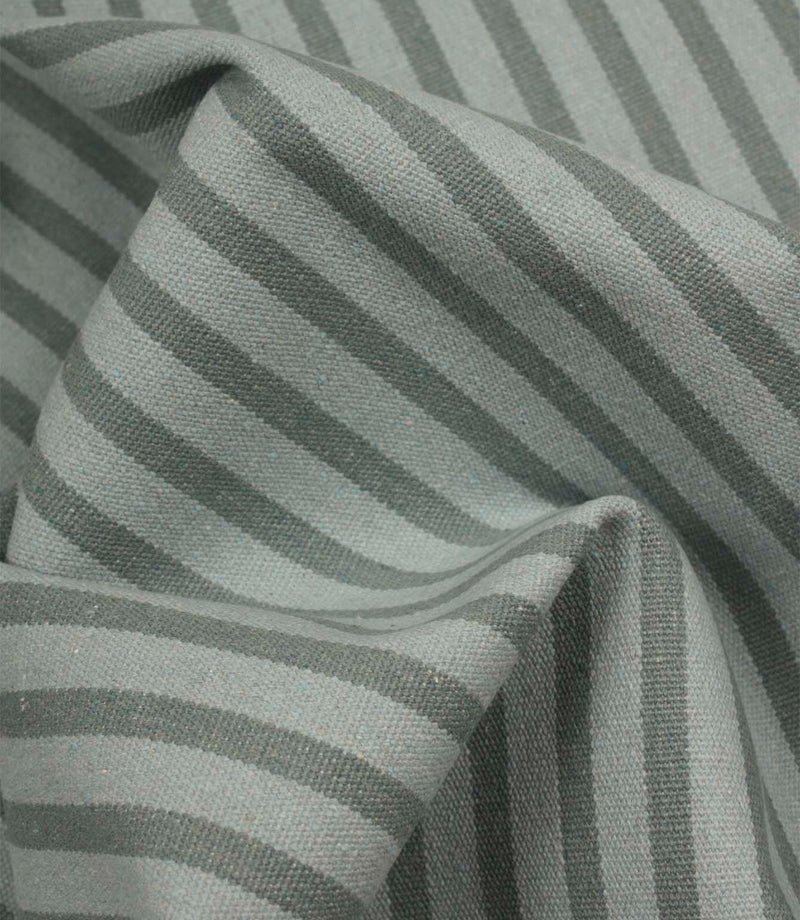 Draped Fernley Stripe woven upholstery fabric featuring steel blue stripes on an ivory ground, demonstrating natural movement and texture.