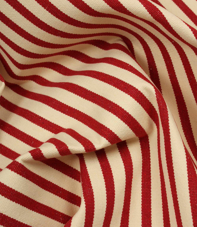Draped Fernley Stripe woven upholstery fabric with wine red stripes on an ivory background, showcasing the fabric's texture and elegant flow.