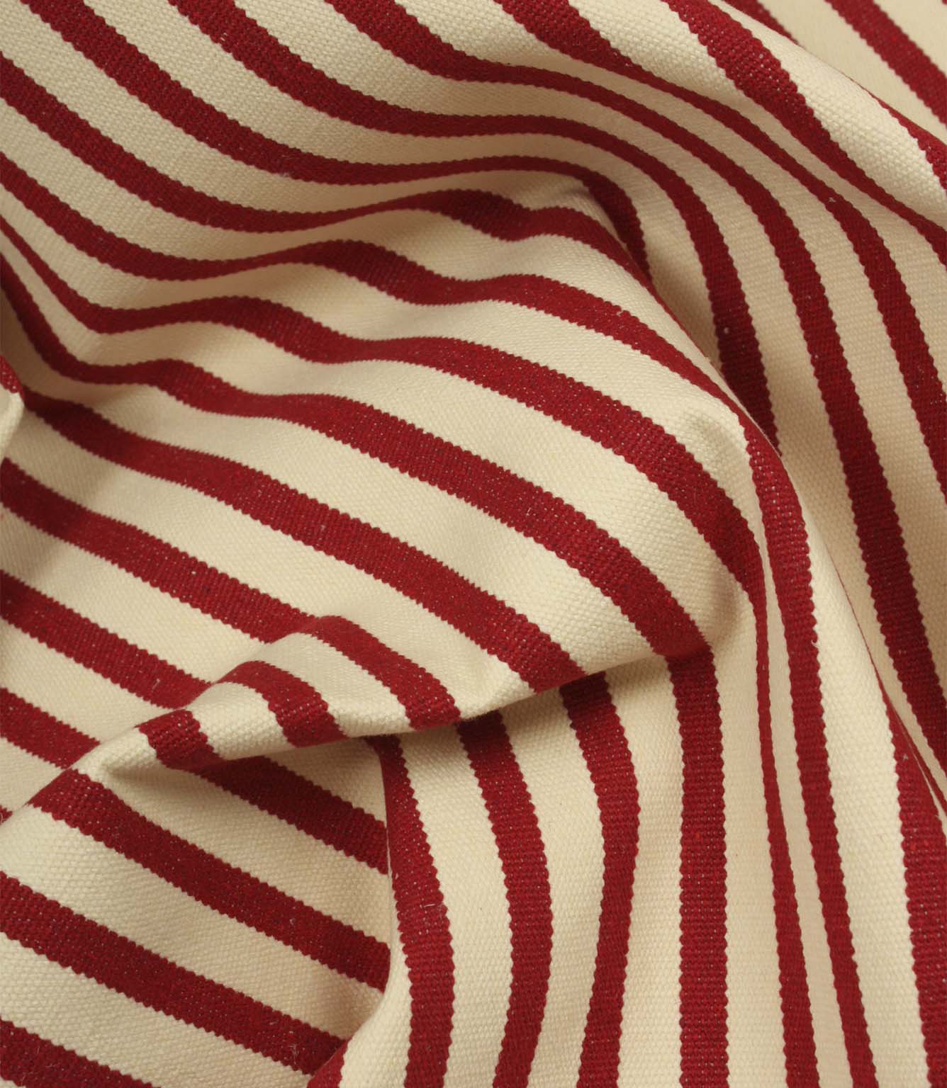 Draped Fernley Stripe woven upholstery fabric with wine red stripes on an ivory background, showcasing the fabric's texture and elegant flow.