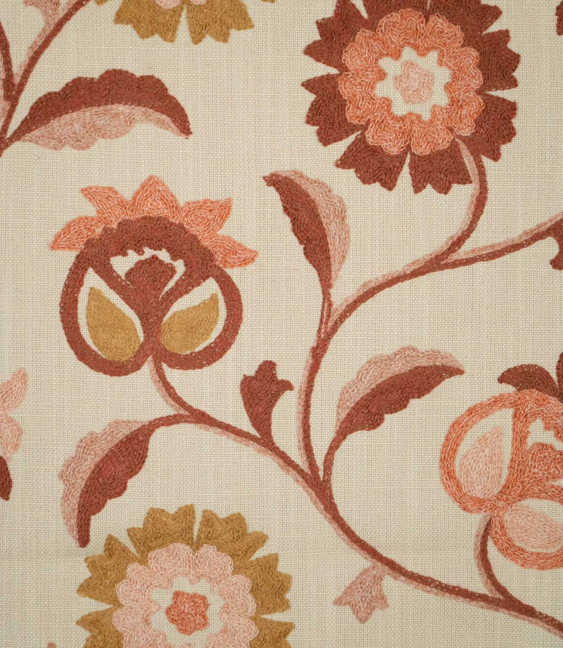Close-up of Foxmere Burnt Sienna embroidered fabric, showing the textured stitching of a stylised floral and vine design in burnt sienna, terracotta, blush pink and ochre against a natural woven cream background.