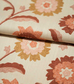 Foxmere Burnt Sienna embroidered floral fabric folded over itself, showing the natural cream woven texture and raised stitching of stylised flowers and leaves in burnt sienna, terracotta, blush pink and warm ochre.