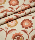 Foxmere Burnt Sienna fabric arranged in soft folds, displaying the flowing embroidered vine pattern with large stylised flowers, leaves and buds in earthy burnt sienna, terracotta, blush pink and ochre tones.