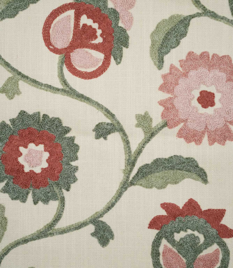 Close-up of Foxmere Chintz embroidered fabric, showing detailed raised stitching across stylised pink and red flowers, sage and deeper green leaves, curved stems and decorative flower buds on a textured natural cream base.