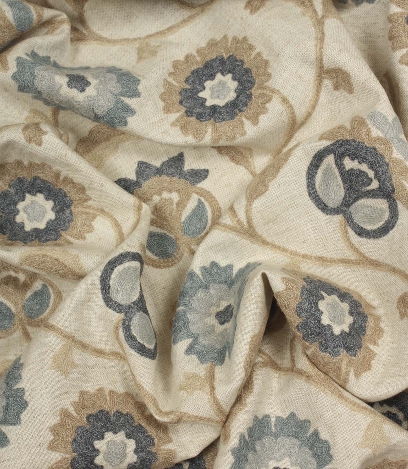 Draped embroidered fabric featuring elegant floral motifs in cornflower blue, slate grey and beige with a soft, flowing finish.