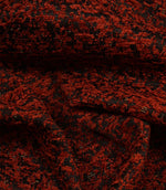 Draped Galaxy contemporary fabric demonstrating its luxurious handle and abstract woven pattern in copper and black colours.