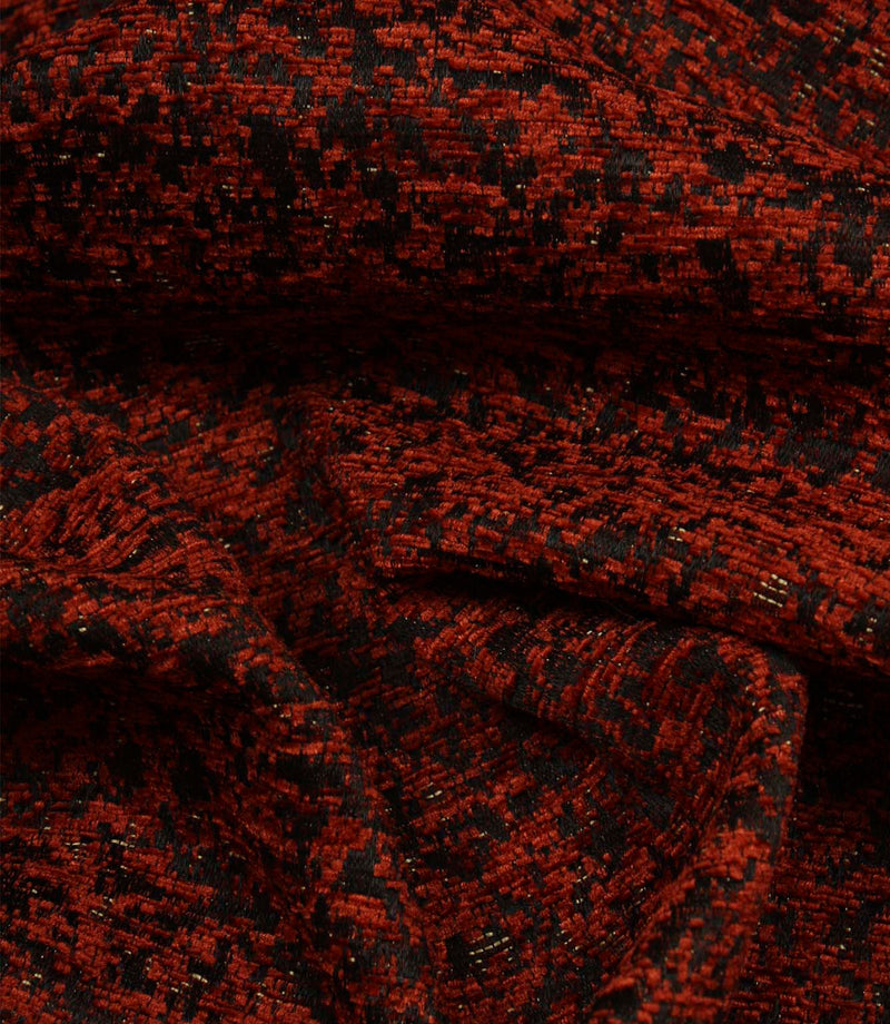 Draped Galaxy contemporary fabric demonstrating its luxurious handle and abstract woven pattern in copper and black colours.
