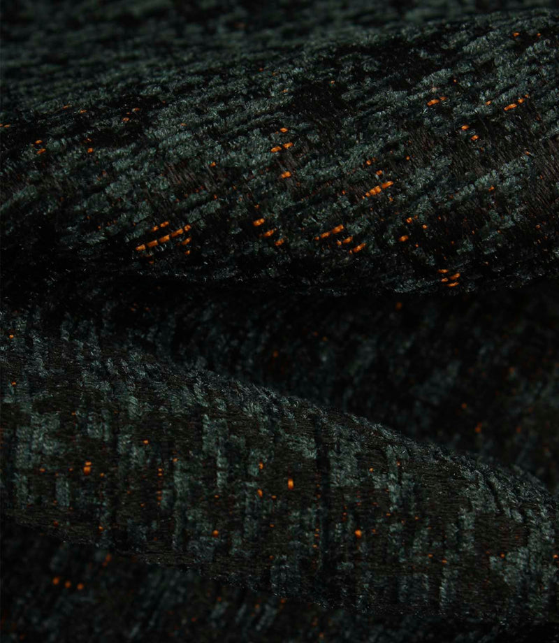 Detailed macro view of Galaxy emerald upholstery fabric, revealing the tactile texture, layered weave and subtle metallic copper highlights.