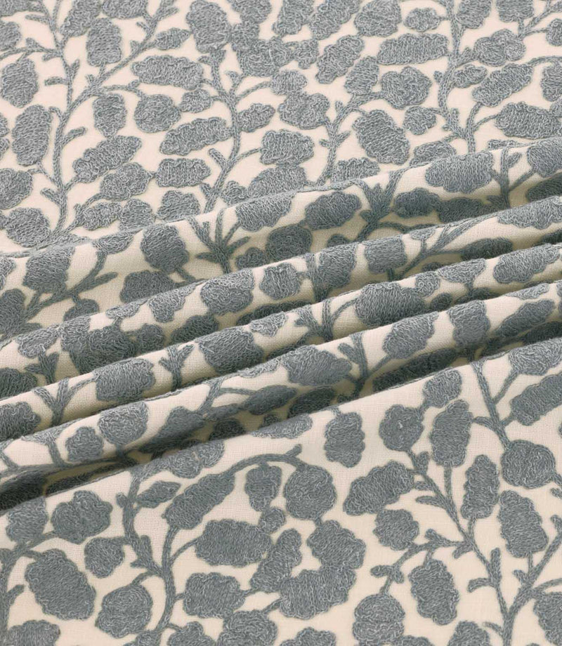 Gardiner Sandytan fabric featuring warm sandy brown textured leaf motifs and delicate embroidered branches on a natural cream background.