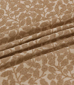 Close-up of Gardiner Sandytan fabric draped in soft folds, highlighting the warm sandy brown embroidered leaves, delicate stems and textured natural background.