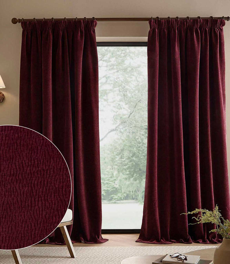 Deep beetroot red Heath washed velvet pencil pleat curtains frame a tall window, with a circular close-up highlighting the fabric’s textured surface.