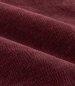 Close-up of folded deep beetroot red Heath washed velvet fabric, showing its plush pile, subtle woven texture and softly shaded finish.