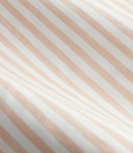 Close-up detail of blush pink and cream striped curtain fabric arranged in soft folds, showing the fine woven texture and evenly spaced vertical stripe design.