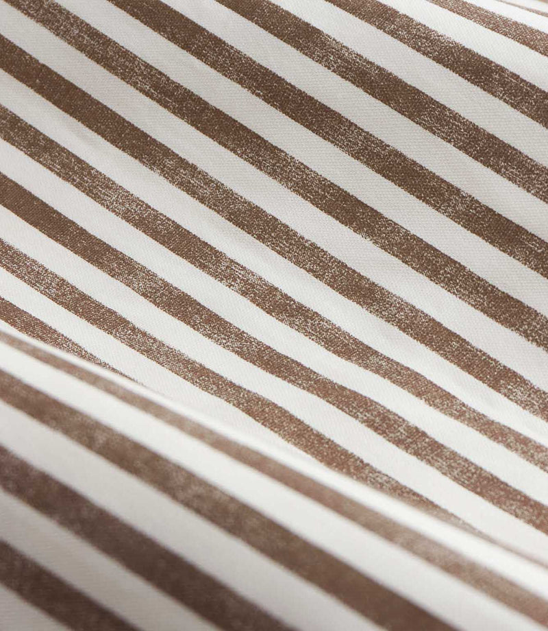 Close-up of brown and cream striped curtain fabric arranged in soft folds, showing the woven texture and slightly irregular printed vertical stripes.