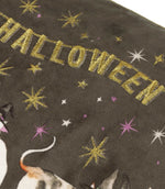 Close-up of the charcoal grey velvet Halloween Pawty cushion showing metallic gold embroidered Happy Halloween lettering with gold, white and purple embroidered stars.