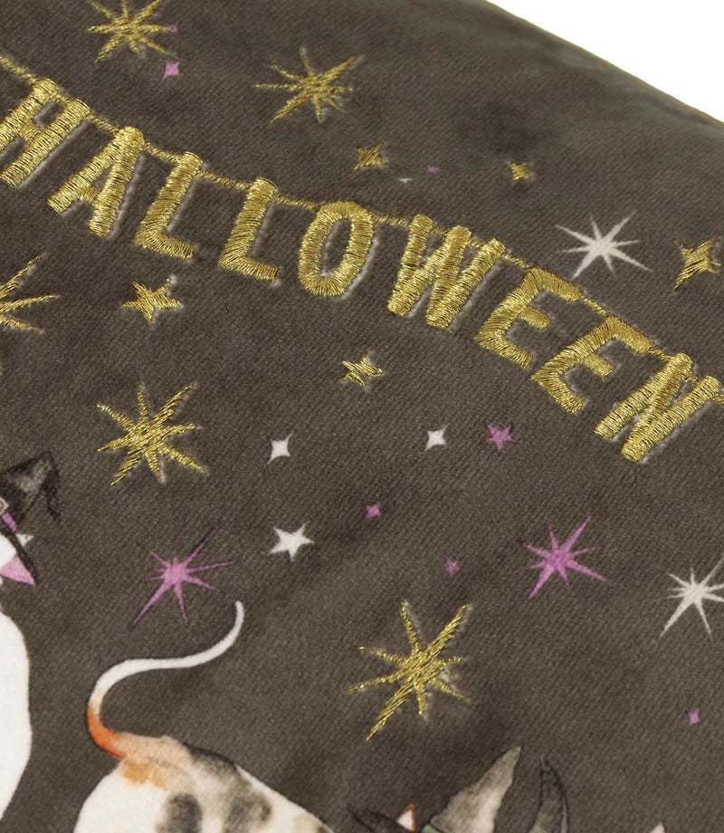 Close-up of the charcoal grey velvet Halloween Pawty cushion showing metallic gold embroidered Happy Halloween lettering with gold, white and purple embroidered stars.