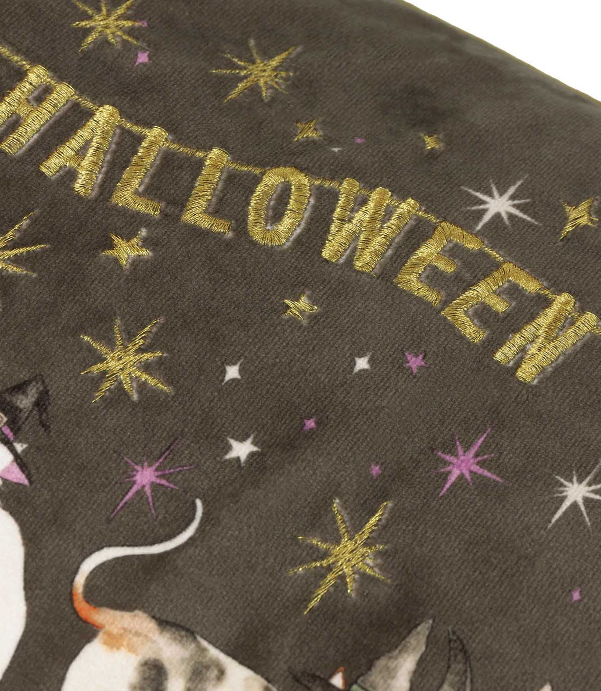 Close-up of the charcoal grey velvet Halloween Pawty cushion showing metallic gold embroidered Happy Halloween lettering with gold, white and purple embroidered stars.