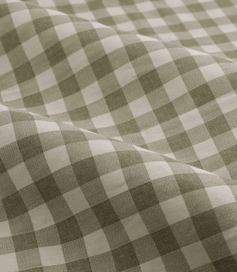 A close-up of draped fabric with a classic gingham check pattern in sage green and off-white.