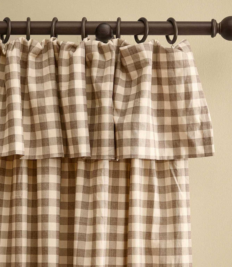 Harriet natural beige and cream gingham check fully lined curtain with a gathered ruffle flop-top header, shown hanging from a dark wooden curtain pole.