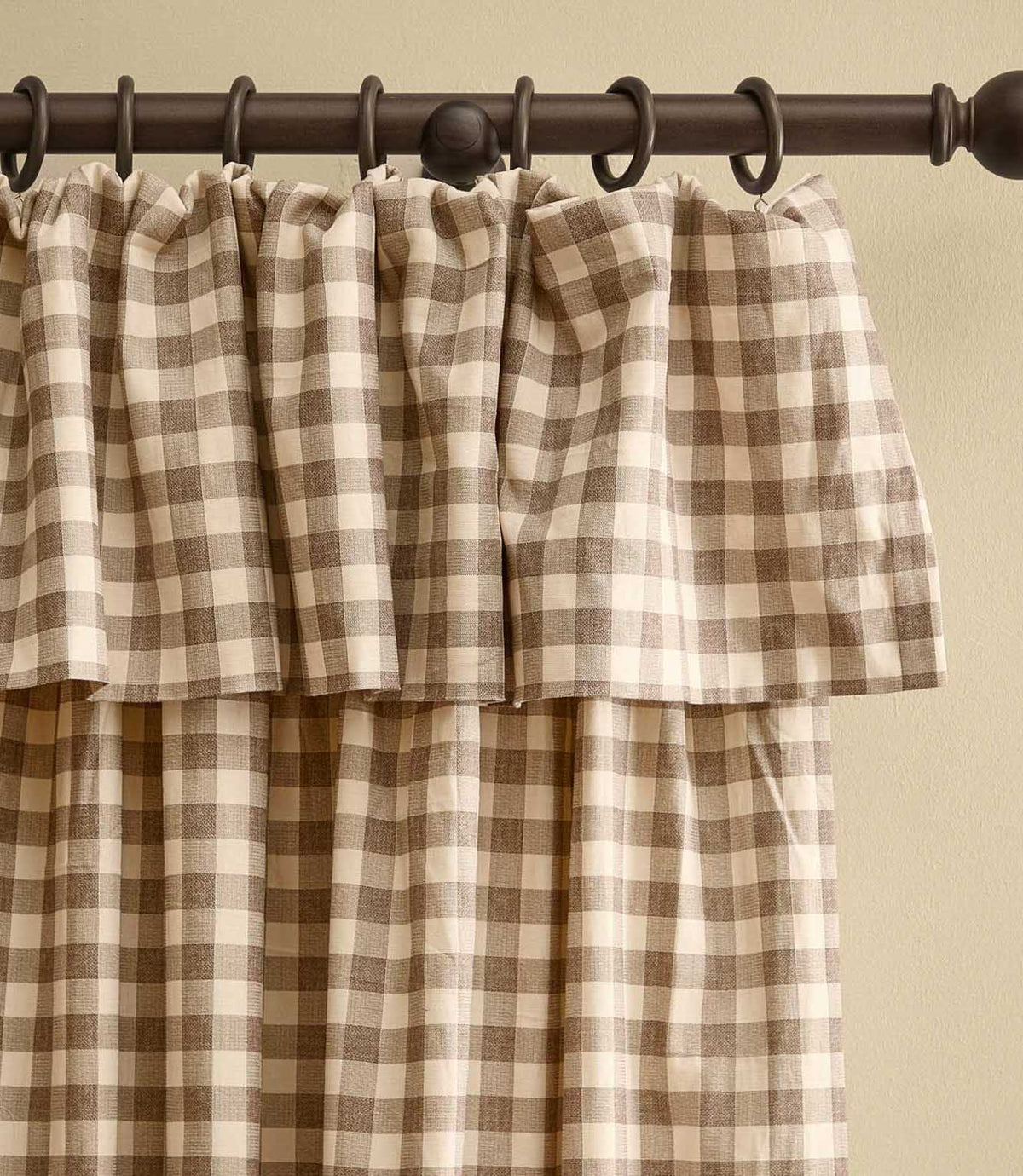 Harriet natural beige and cream gingham check fully lined curtain with a gathered ruffle flop-top header, shown hanging from a dark wooden curtain pole.