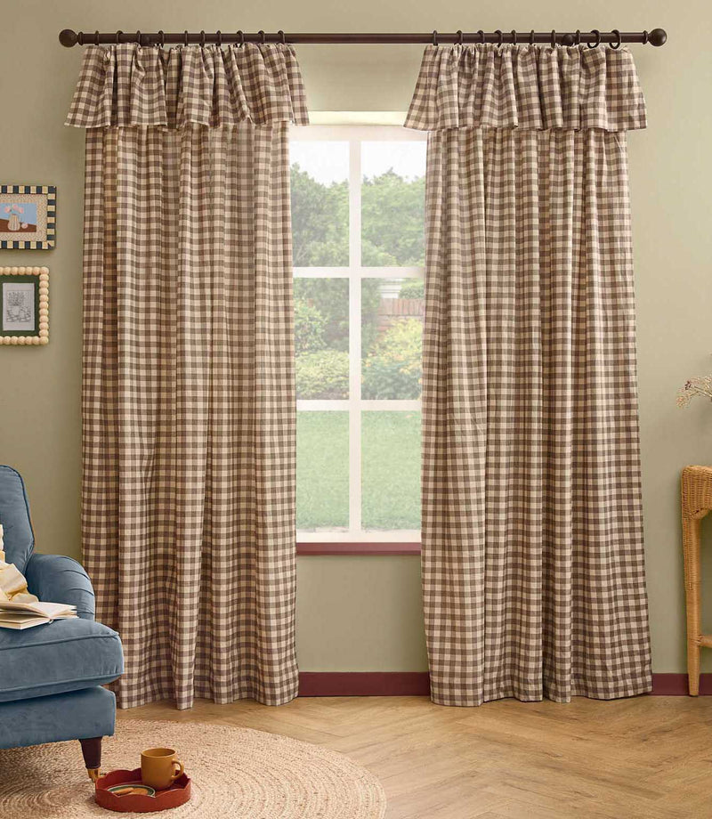 Pair of Harriet natural beige and cream gingham check fully lined curtains with ruffle flop-top headers, framing a large window in a relaxed living room.