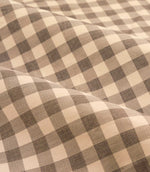 Close-up detail of Harriet natural beige and cream gingham check fabric draped in soft folds, showing the woven texture and evenly spaced checked design.