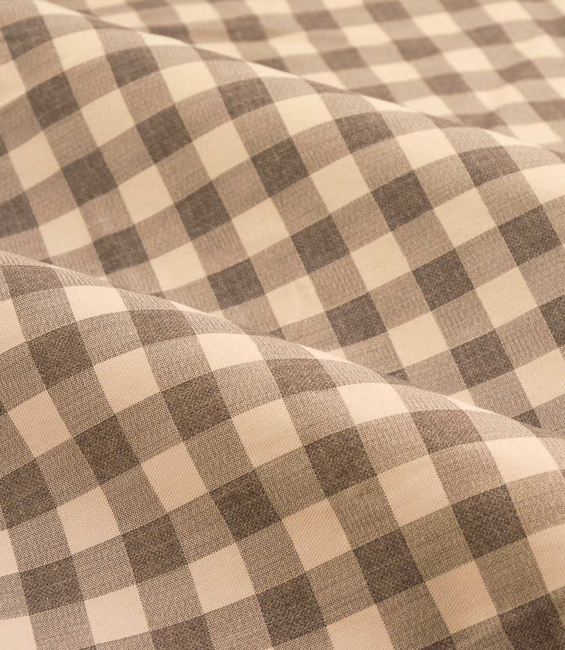Close-up detail of Harriet natural beige and cream gingham check fabric draped in soft folds, showing the woven texture and evenly spaced checked design.