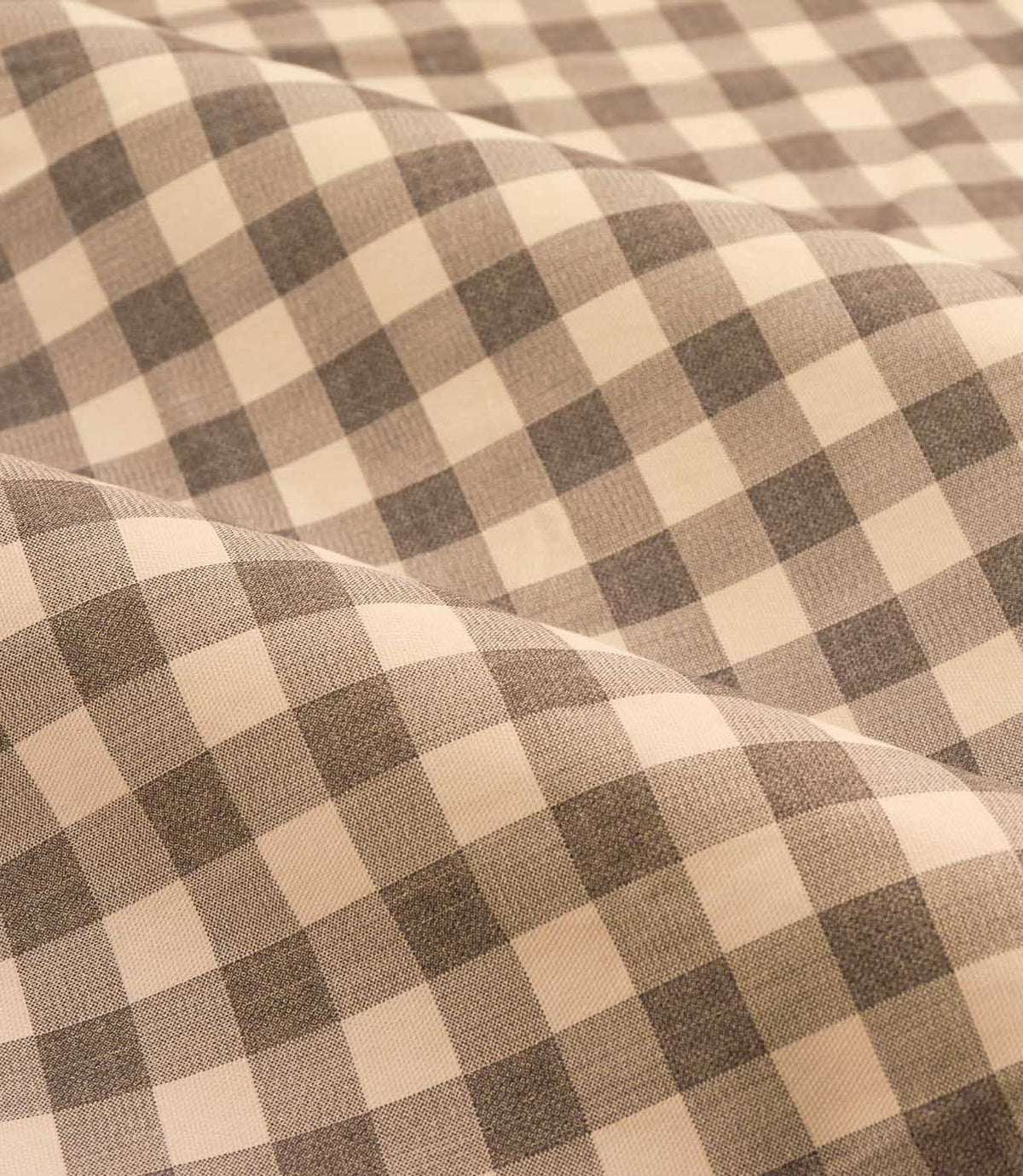 Close-up detail of Harriet natural beige and cream gingham check fabric draped in soft folds, showing the woven texture and evenly spaced checked design.