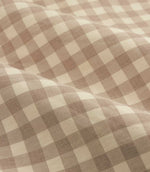 Close-up detail of natural beige and cream gingham check cotton curtain fabric arranged in soft folds, showing the woven texture and checked pattern.