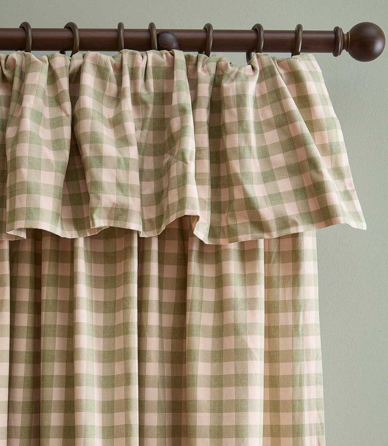 Harriet pink and sage green gingham check fully lined curtain with a softly gathered ruffle flop-top header, hanging from a dark wooden curtain pole.