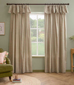 Pair of Harriet pink and sage green gingham check fully lined curtains with ruffle flop-top headers, framing a large window in a relaxed living room.