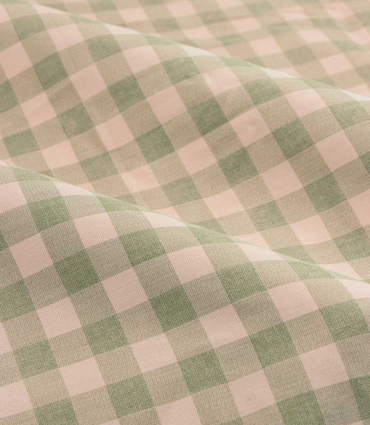 Close-up detail of Harriet pink and sage green gingham check fabric arranged in soft folds, showing the woven texture and classic checked design.