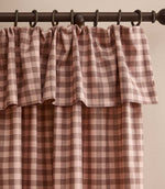 Harriet pink and brown gingham check fully lined curtain with a softly gathered ruffle flop-top header, hanging from a dark wooden curtain pole.