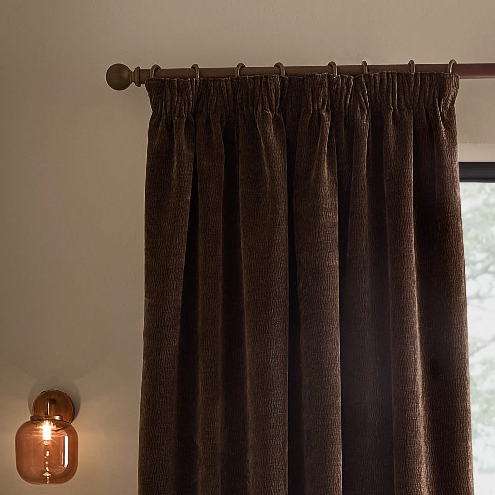 Espresso brown washed velvet pencil pleat curtain hanging from a dark wooden curtain pole, showing the gathered heading and textured finish.