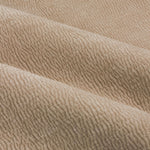 Close-up of natural linen beige washed velvet curtain fabric arranged in soft folds, highlighting its plush surface, fine ribbed texture and subtle tonal variation.