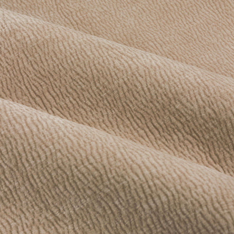 Close-up of natural linen beige washed velvet curtain fabric arranged in soft folds, highlighting its plush surface, fine ribbed texture and subtle tonal variation.