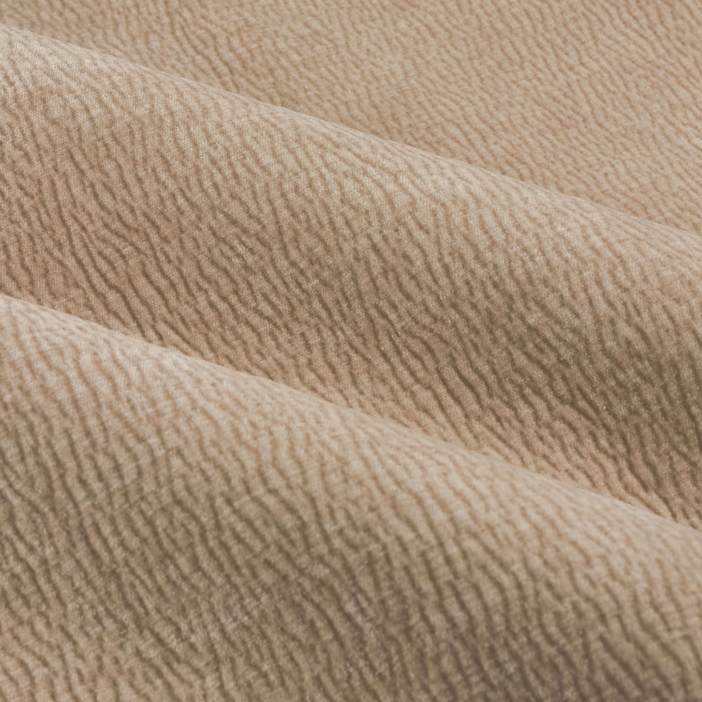 Close-up of natural linen beige washed velvet curtain fabric arranged in soft folds, highlighting its plush surface, fine ribbed texture and subtle tonal variation.