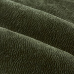 Close-up of olive green washed velvet curtain fabric arranged in soft folds, highlighting its plush surface, fine rippled texture and subtle tonal variation.