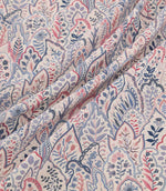 Hitherhill Anemone floral fabric arranged in soft, flowing folds, showcasing its detailed botanical design of layered leaf shapes, delicate flowers and decorative foliage in blush pink, muted blue, navy and lavender tones on an ivory background.